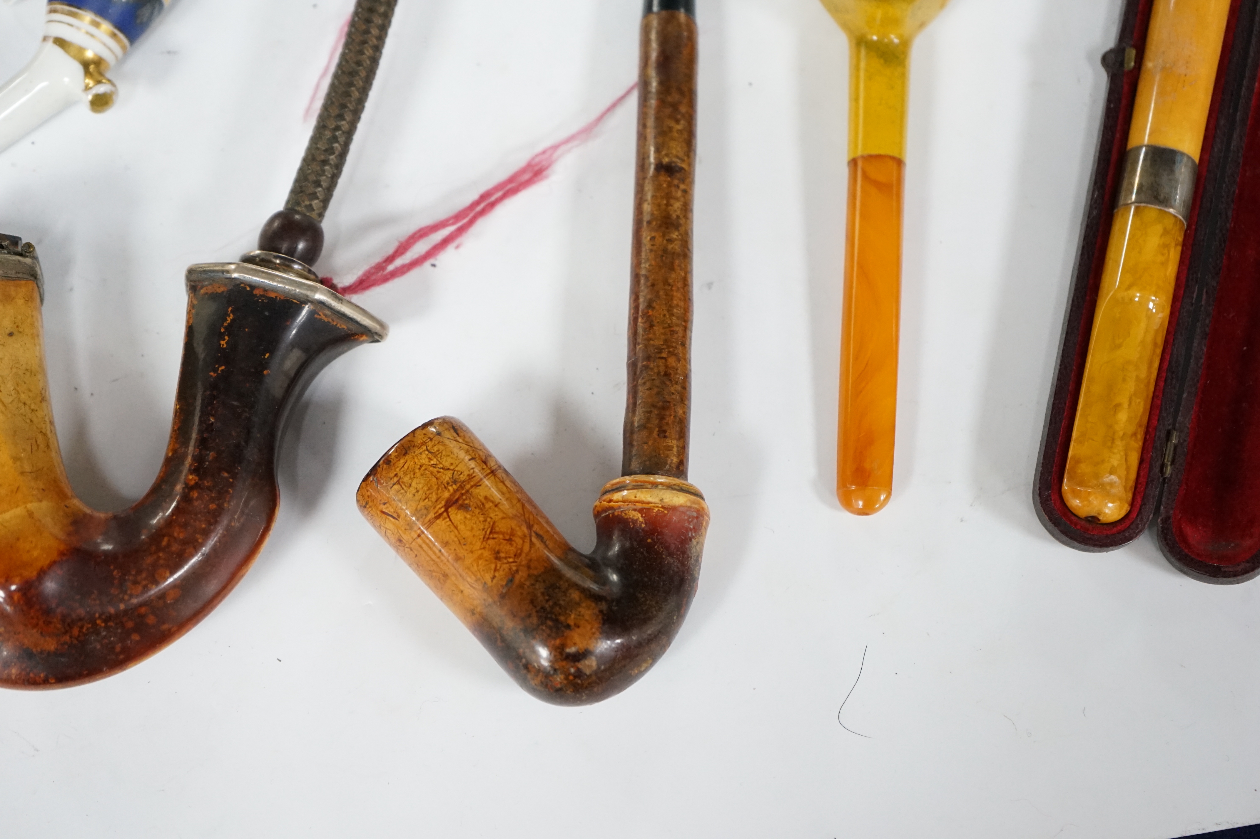 Seven pipes, three with amber mouthpieces, two cased and two without mouthpieces, longest cased pipe 20cm long